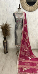 Mannequin wearing a silver dress with a pink saree against a light gray wall.