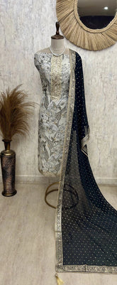 Mannequin wearing a black and silver saree with a decorative mirror in the background.