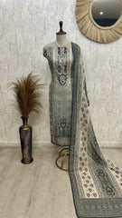 Mannequin wearing a traditional outfit with a patterned dupatta against a textured wall.