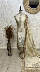 Mannequin wearing a cream-colored embroidered dress with a matching dupatta against a light gray wall.