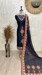 Navy blue embroidered dress with a matching dupatta on a mannequin against a textured wall.