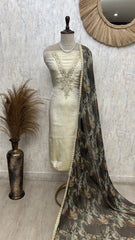 Mannequin wearing a cream saree with a floral patterned dupatta against a textured wall.