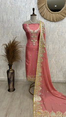 Pink saree with gold border on a mannequin against a neutral wall.