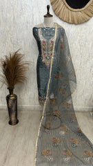 Traditional embroidered outfit on a mannequin against a neutral wall.