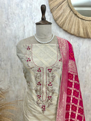 Mannequin wearing a cream embroidered blouse with a pink dupatta against a textured wall.