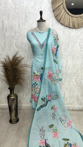 Light blue embroidered dress with floral patterns on a mannequin against a white wall.