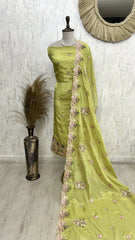 Green saree with floral patterns on a mannequin against a neutral background