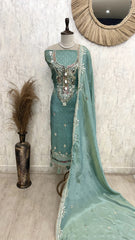 Teal embroidered traditional outfit with dupatta on a mannequin against a light background