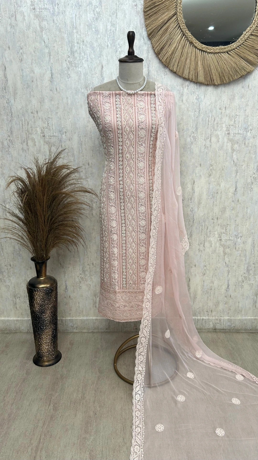 Mannequin wearing a light pink embroidered dress with a matching dupatta against a neutral background.