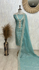 Teal embroidered dress with matching dupatta on a mannequin against a neutral wall.